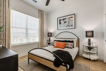 an apartment bedroom with a bed and a large window